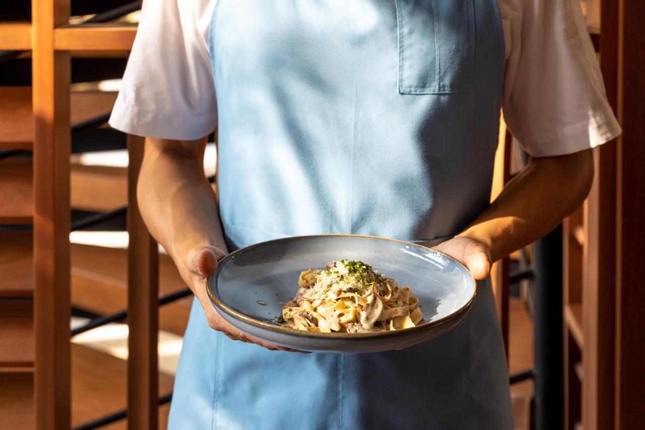 Outrigger Surin Beach Resort - Sha Extra Plus Bagian luar foto A server holding a plate of pasta