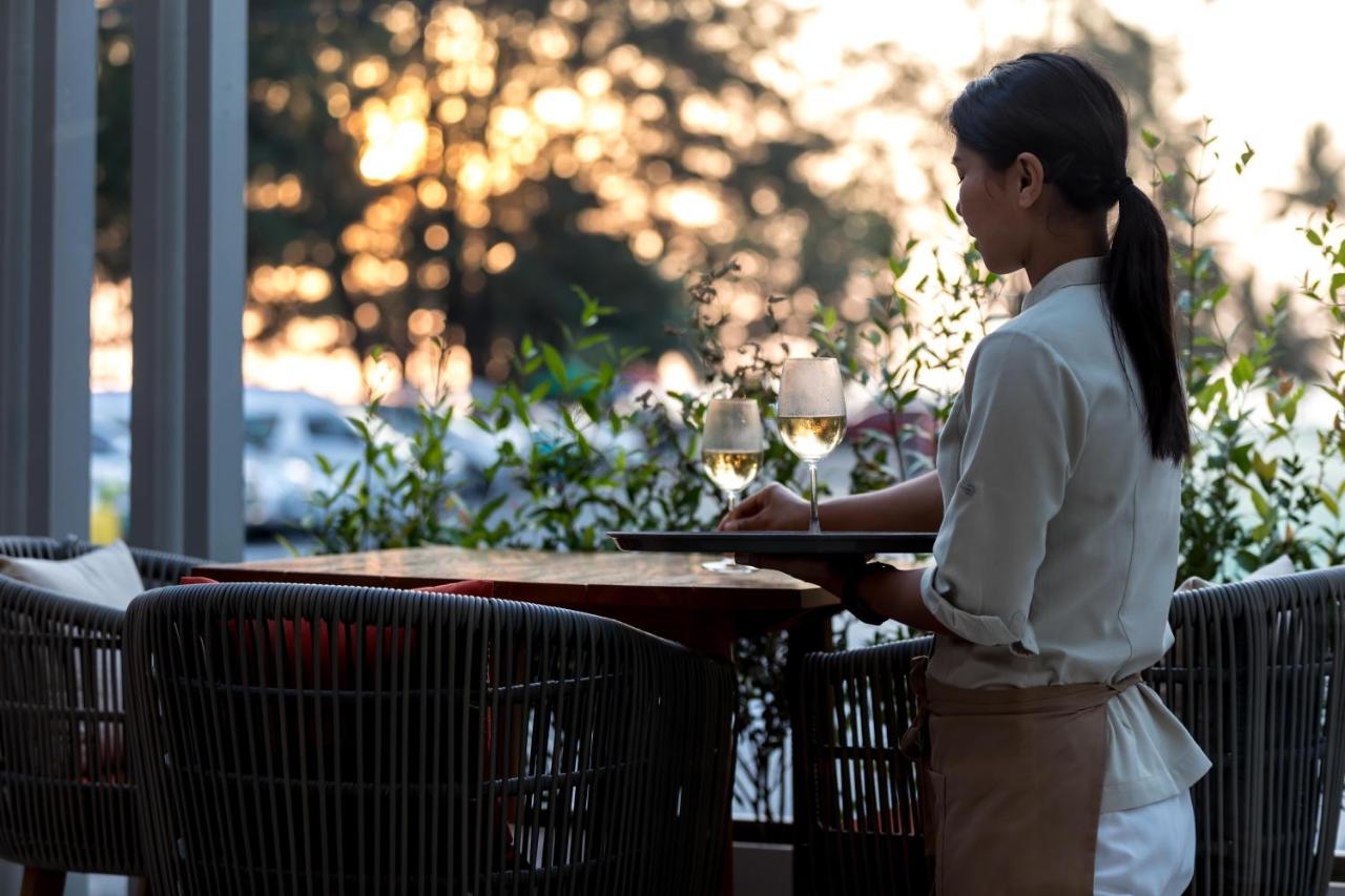 Outrigger Surin Beach Resort - Sha Extra Plus Bagian luar foto A waitress clearing a table